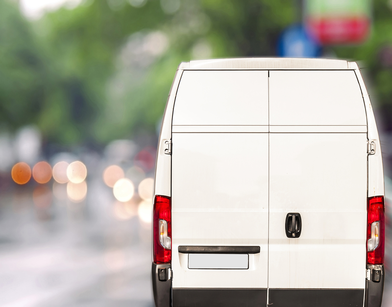 White delivery Van driving fast on city blurr bokeh street white van